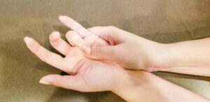 Trigger finger looks like a finger that remains in a bent position. This image shows someone using their other hand to press on their palm to try and relieve the tension of the trigger finger of the ring finger.